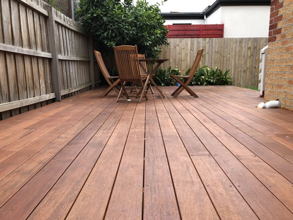 Low-angle view of premium hardwood deck by Bayside deck builder in Highett, showcasing flawless finish and expansive entertaining space.